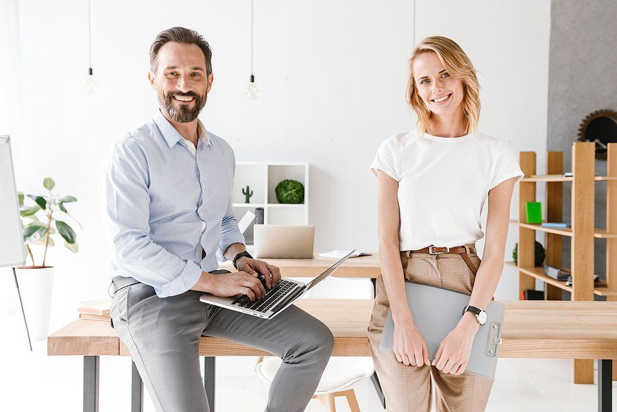 Smiling man and woman talk about endorsing each other on LinkedIn at work