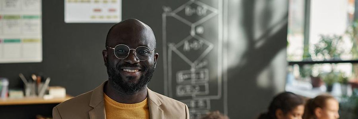 Smiling teacher in his classroom
