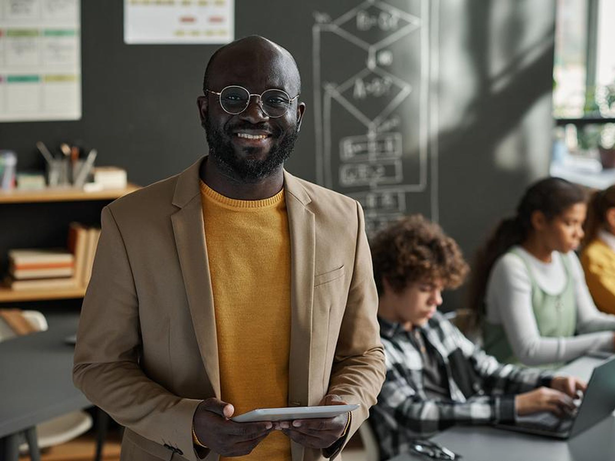 Smiling teacher in his classroom