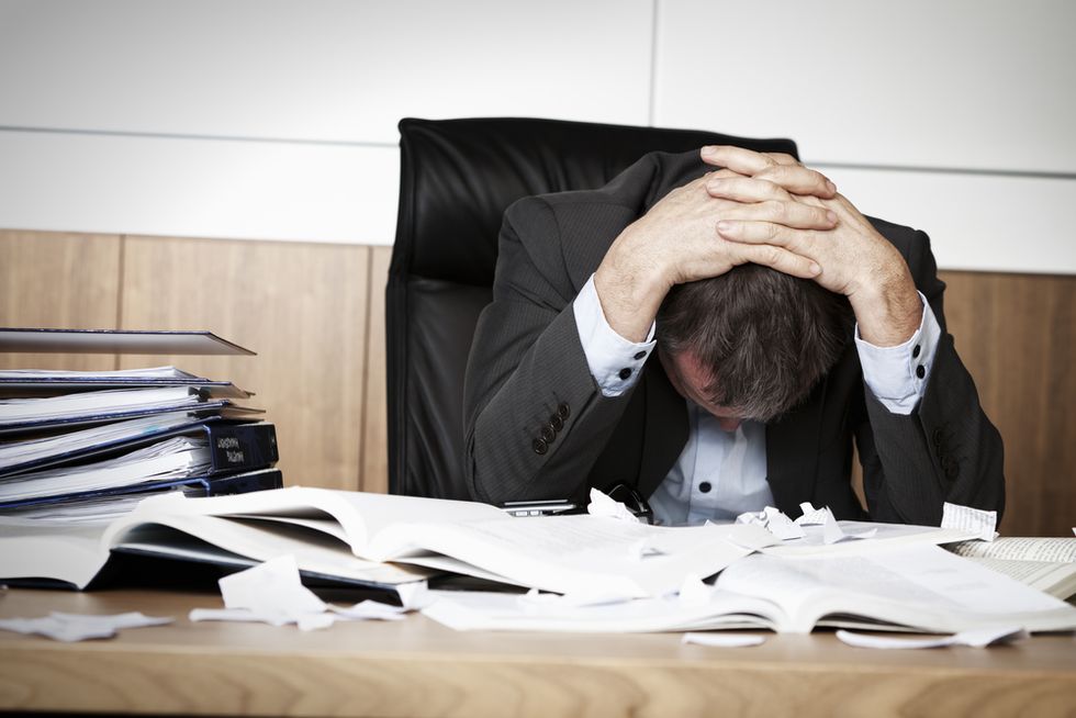 Stressed out employee struggles to do his job.