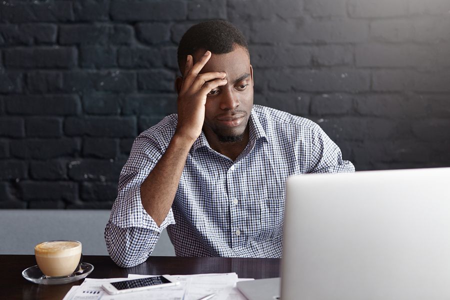 Stressed young professional on laptop shows frustration after being rejected from a job