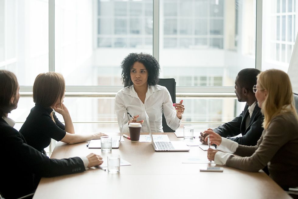 Successful female executive speaks to her employees during a crisis meeting