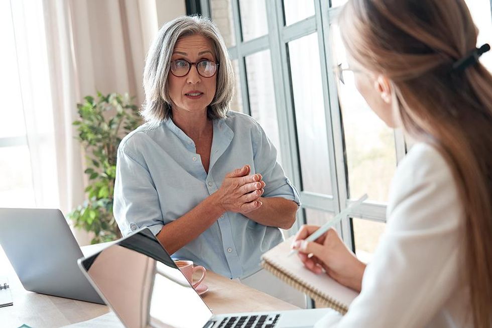 Successful professional woman talks to a work colleague