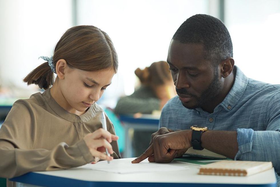 Teacher helps a student with an assignment