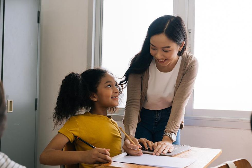 Teacher helps a student with an assignment