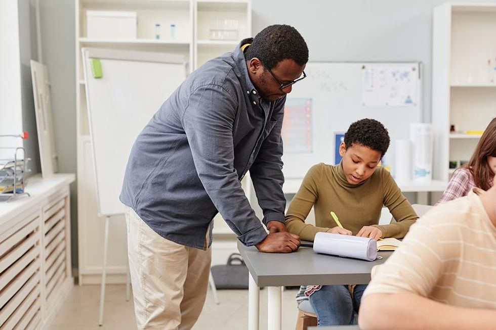 Teacher helps a student with an assignment