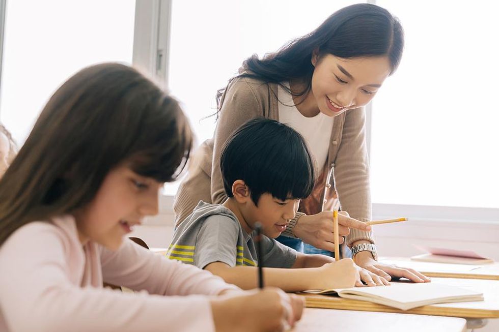 Teacher helps a student with an in-class assignment