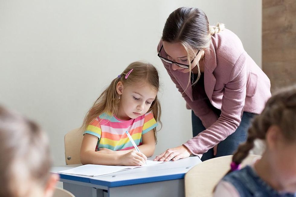 Teacher helps a student