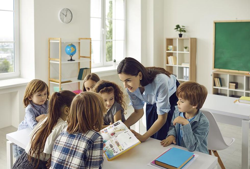 Teacher reads a book to her students