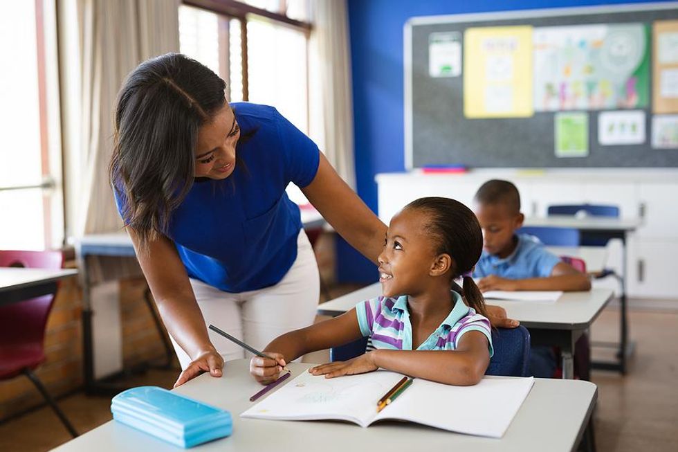 Teacher smiles at one of her students