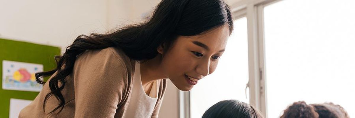 Teacher uses new teaching strategies while helping a student