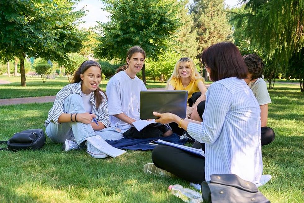 Teacher with students outside on grass