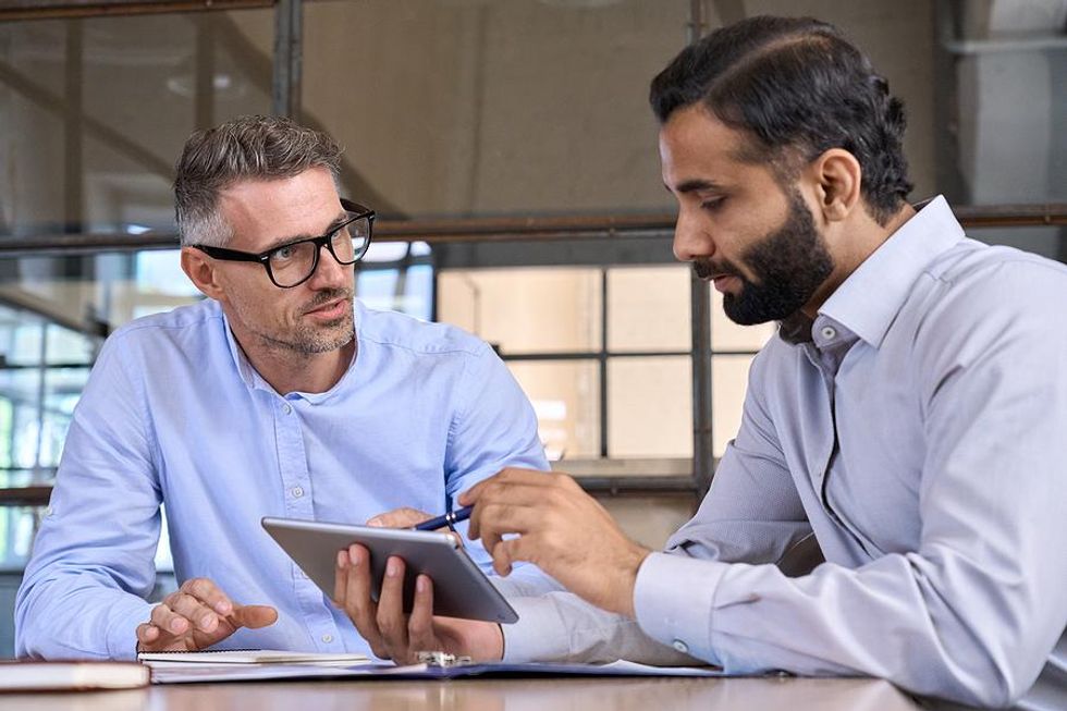 Tech executives talk during a work meeting