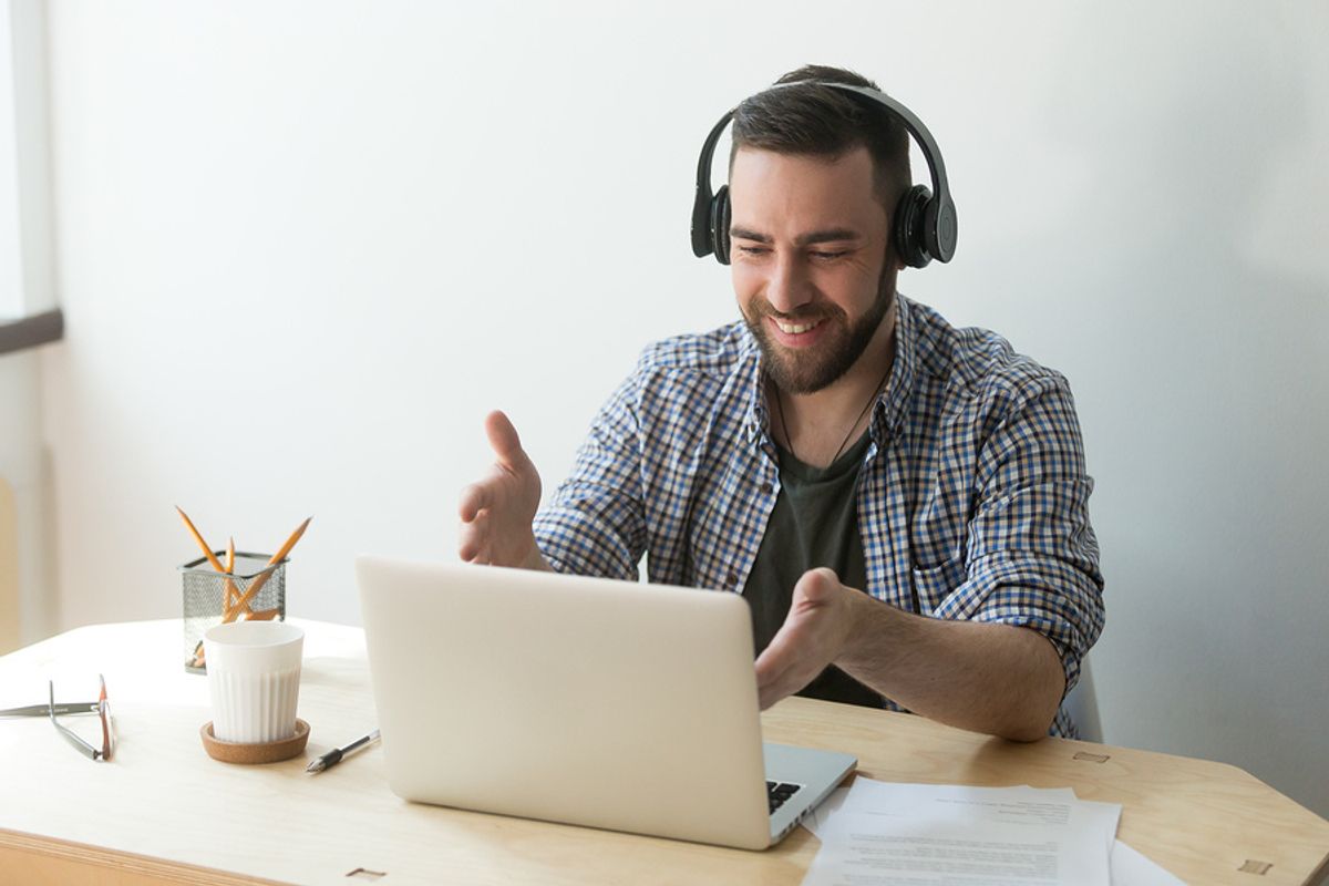 Tech savvy professional uses laptop and headphones for work project