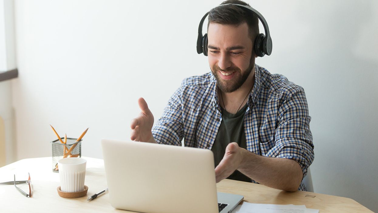 Tech savvy professional uses laptop and headphones for work project