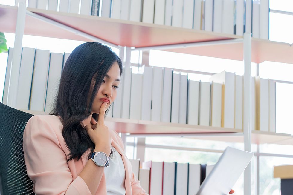 Thinking woman addresses her bad habits with a career coach on her laptop