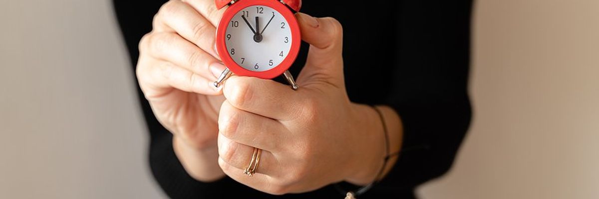 Time management concept, woman holding clock