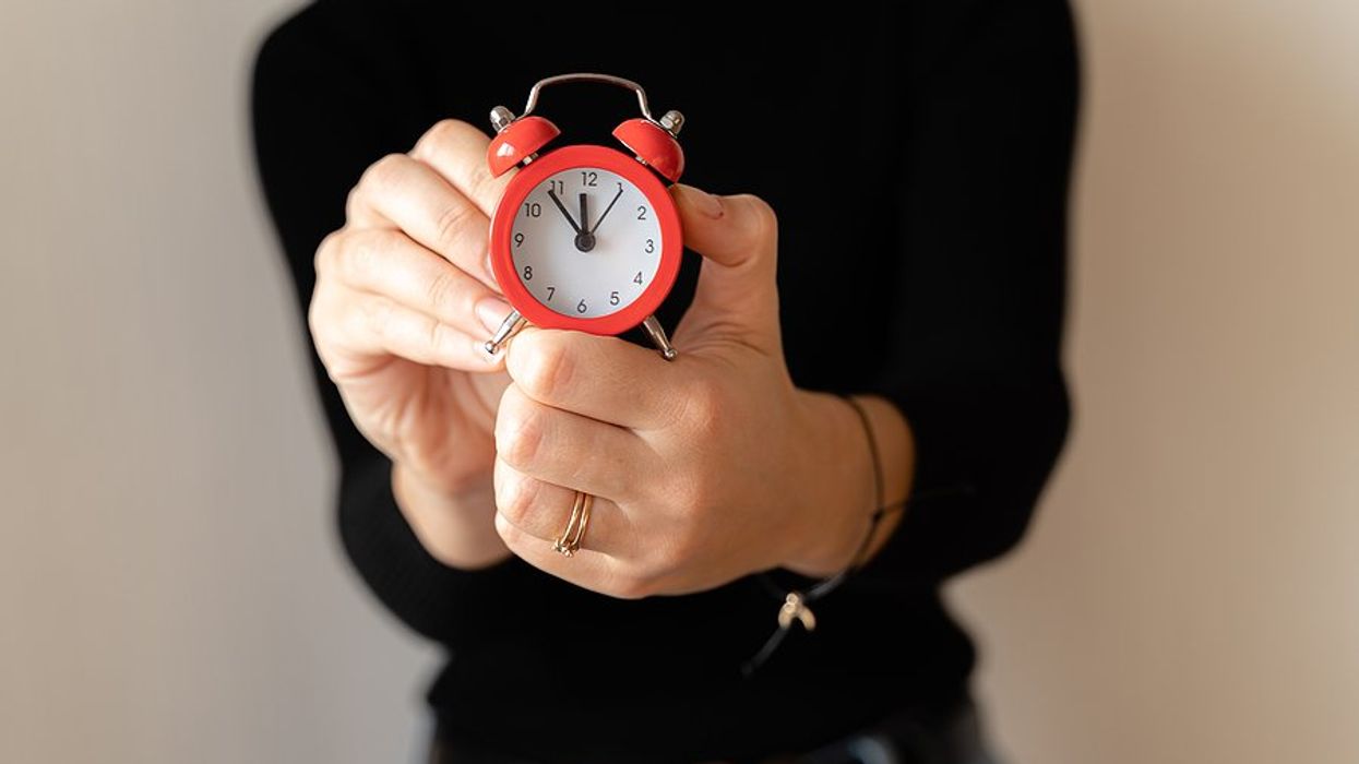 Time management concept, woman holding clock