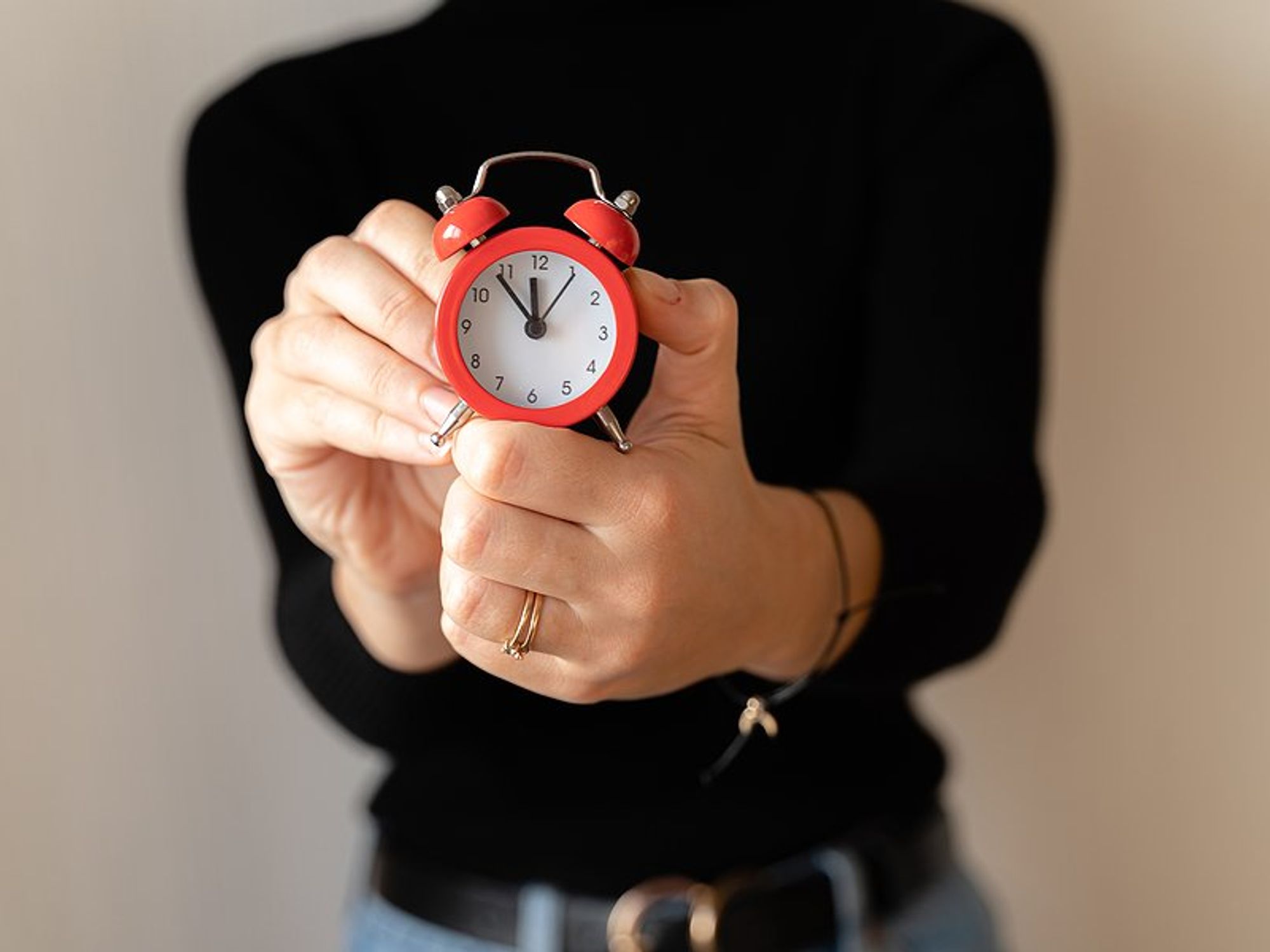 Time management concept, woman holding clock