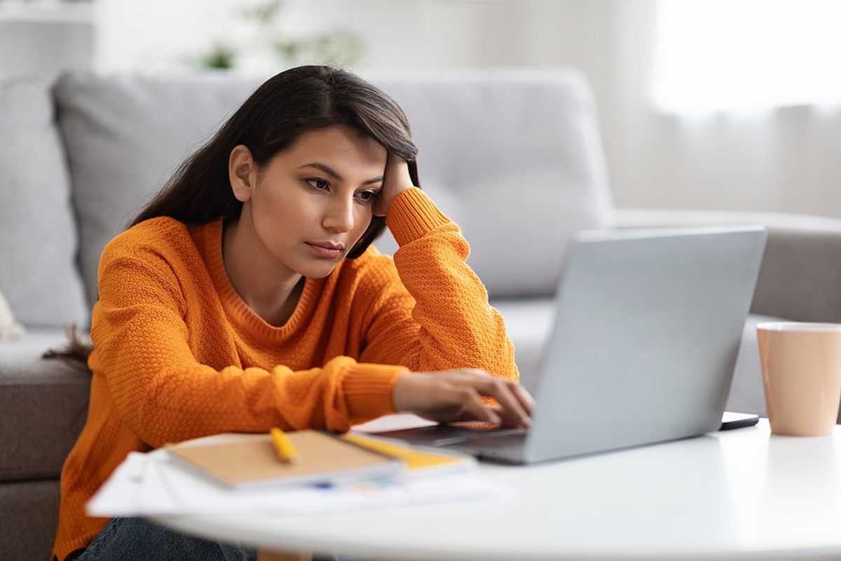 Tired/exhausted/bored/frustrated woman on laptop deals with remote work loneliness
