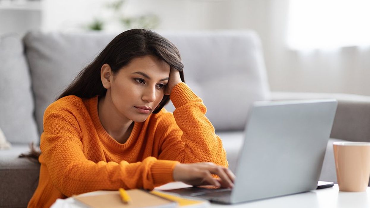 Tired/exhausted/bored/frustrated woman on laptop deals with remote work loneliness