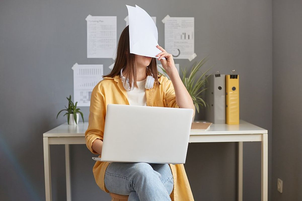 Tired/exhausted/frustrated woman on laptop makes cover letter mistakes