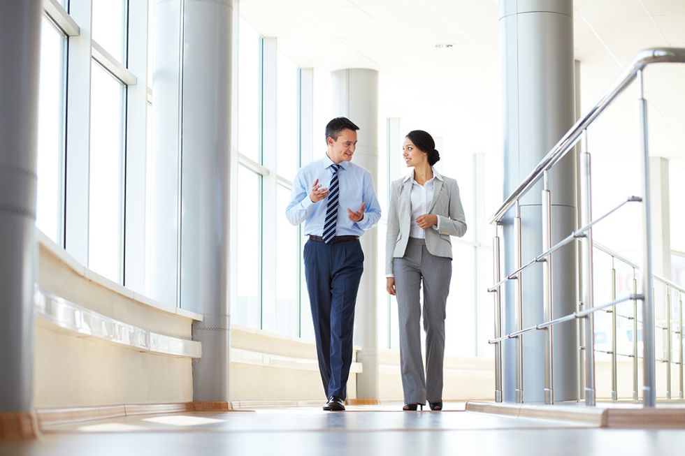 Two business partners walk together and discuss key stakeholders