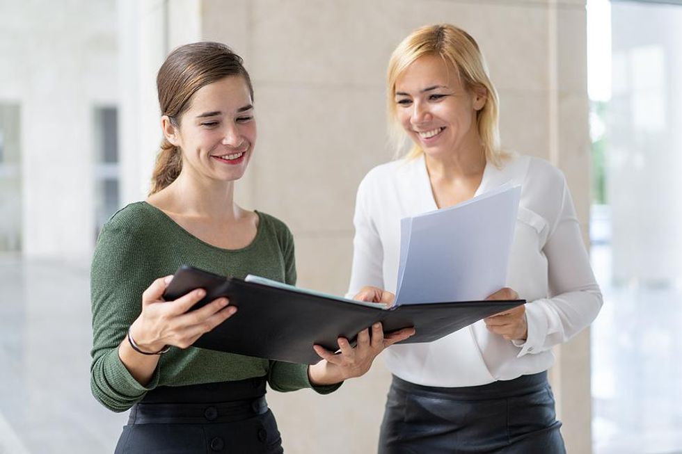 Two co-workers discuss ideas about making their company more efficient.