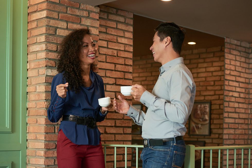 Two co-workers flirt while on a coffee break