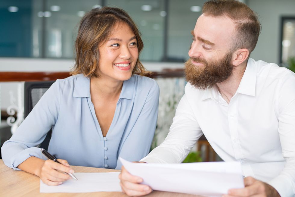 Two co-workers flirting at work