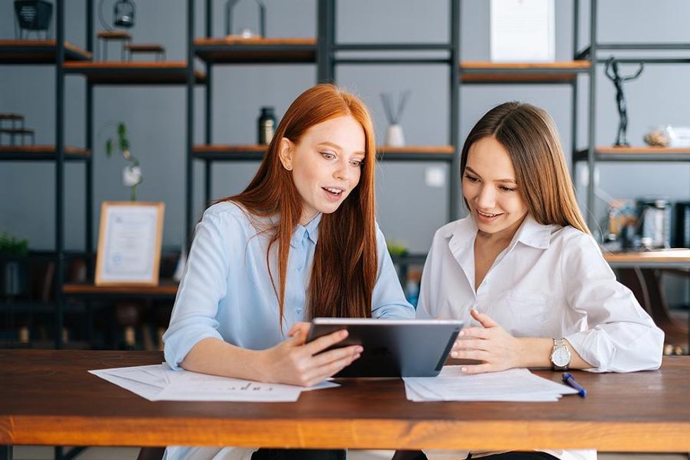 Two coworkers collaborate on a work project