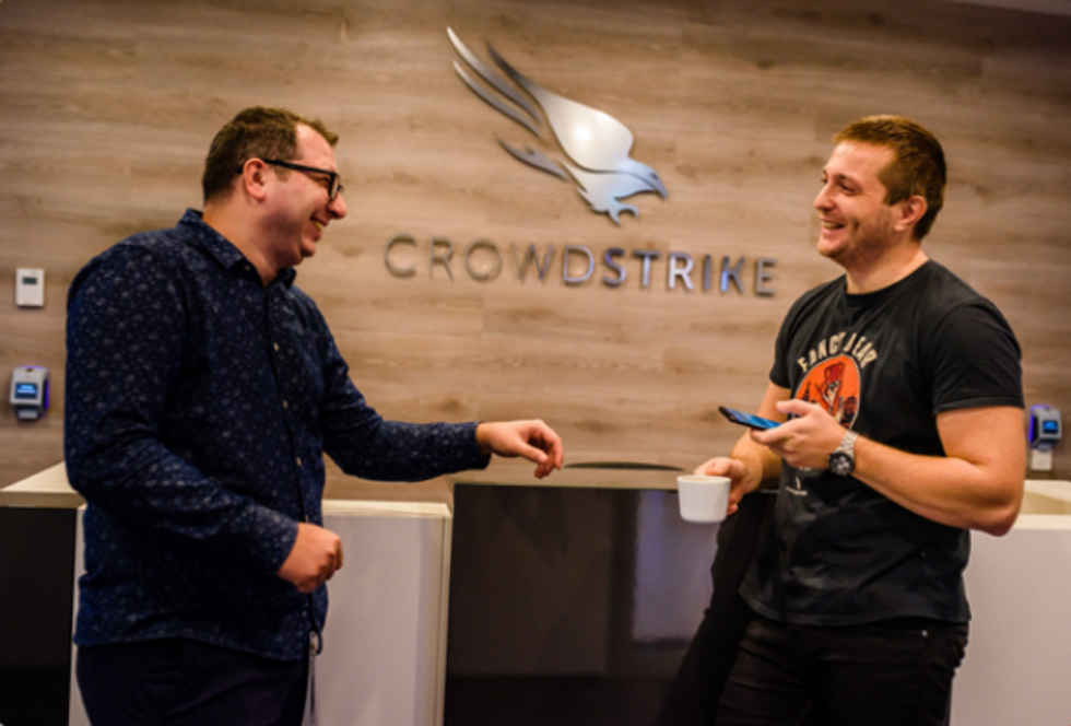 Two CrowdStrike employees chat in the office.