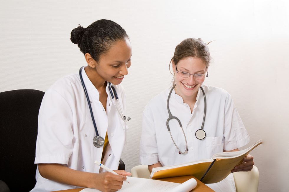 Two nurses discuss a patient's medical file.