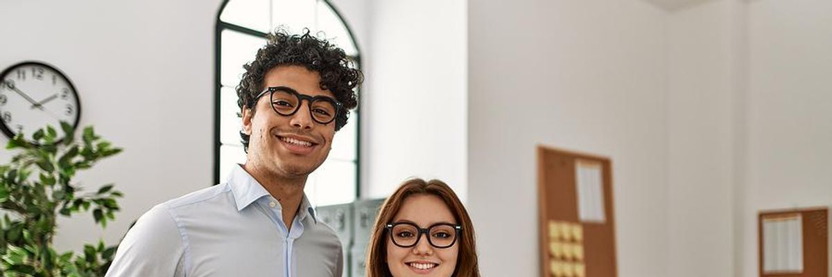 Two professionals smile after a performance review