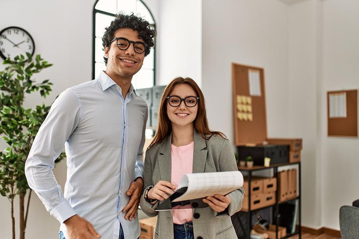 Two professionals smile after a performance review