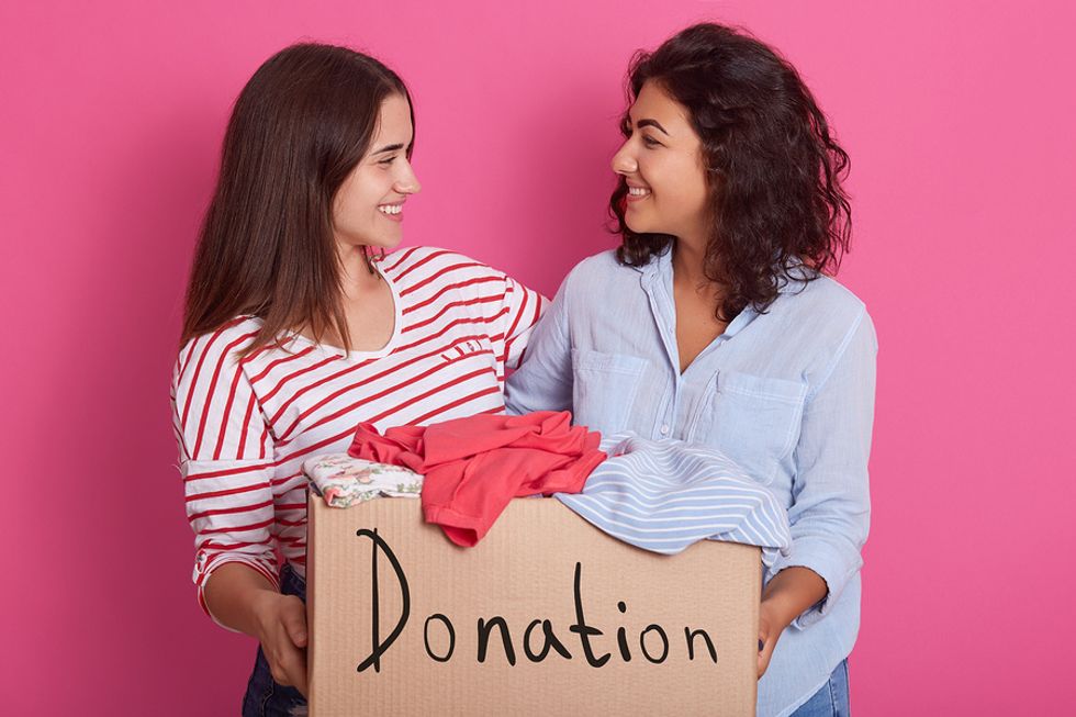 Two woman donate clothes to a charity their company supports