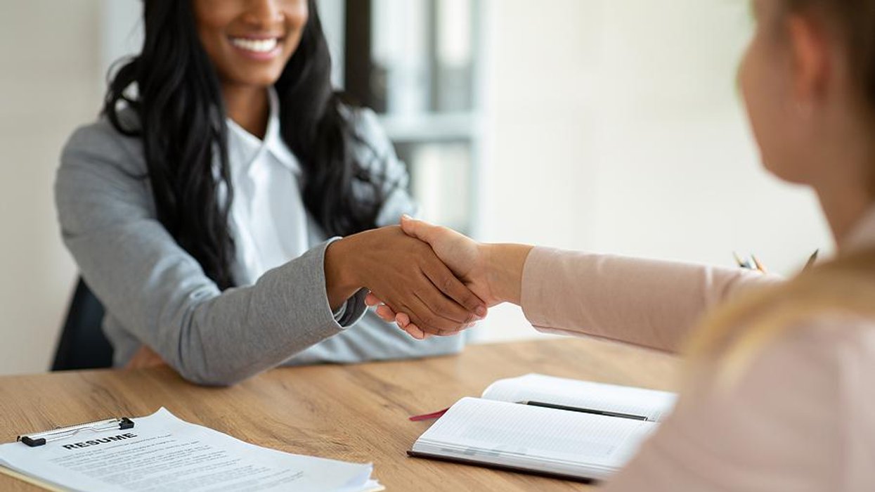 Two women shake hands before an informational interview