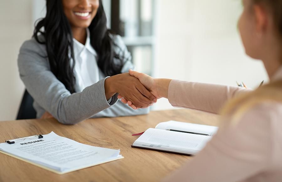 Two women shake hands before an informational interview