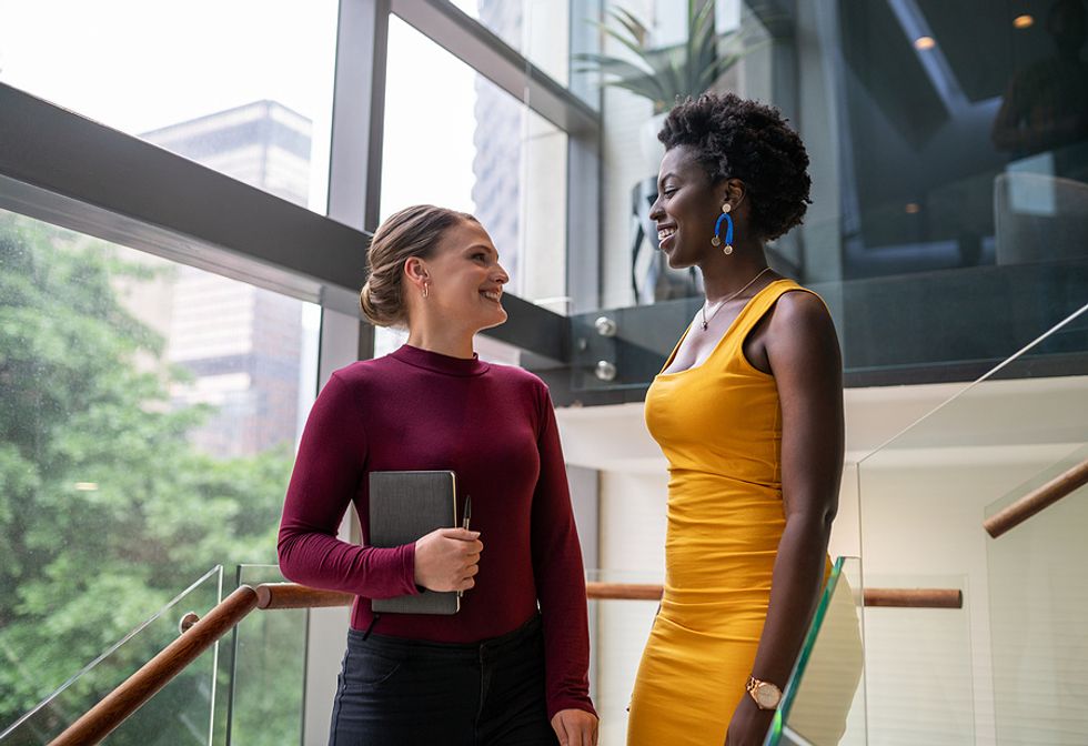 Two women smile after a conversation about microaggressions in the workplace