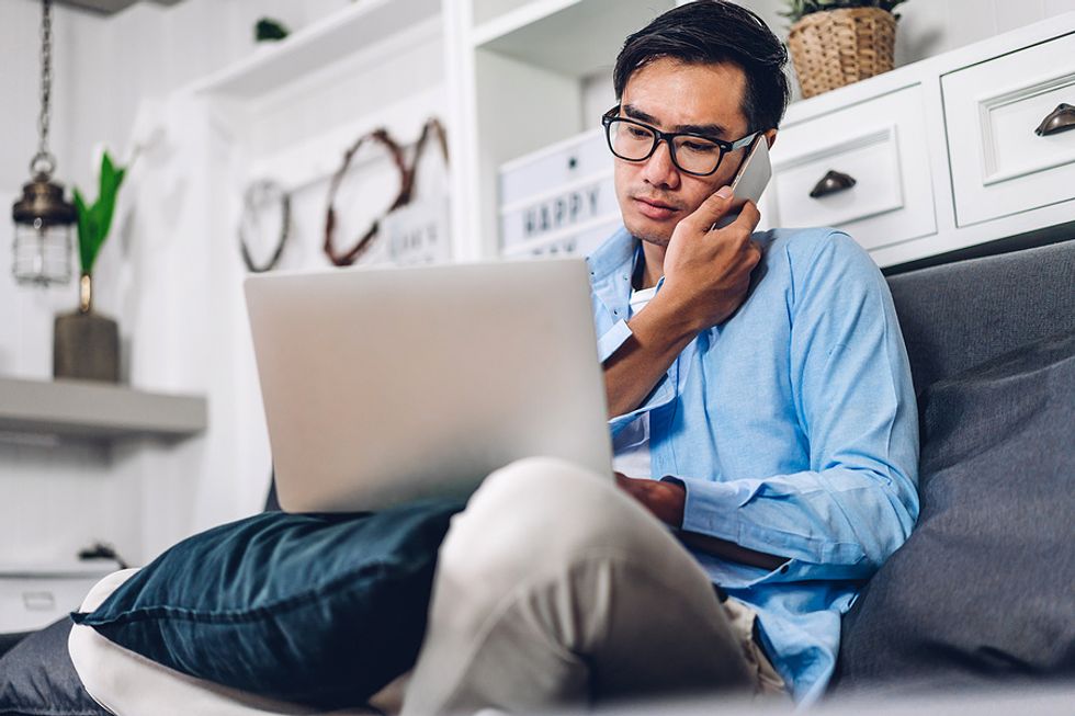 Unemployed man on laptop and phone calls HR and recruiters to find a job