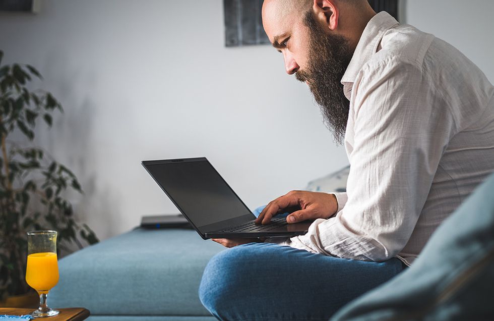 Unemployed man on laptop makes the mistake of posting his resume to job boards