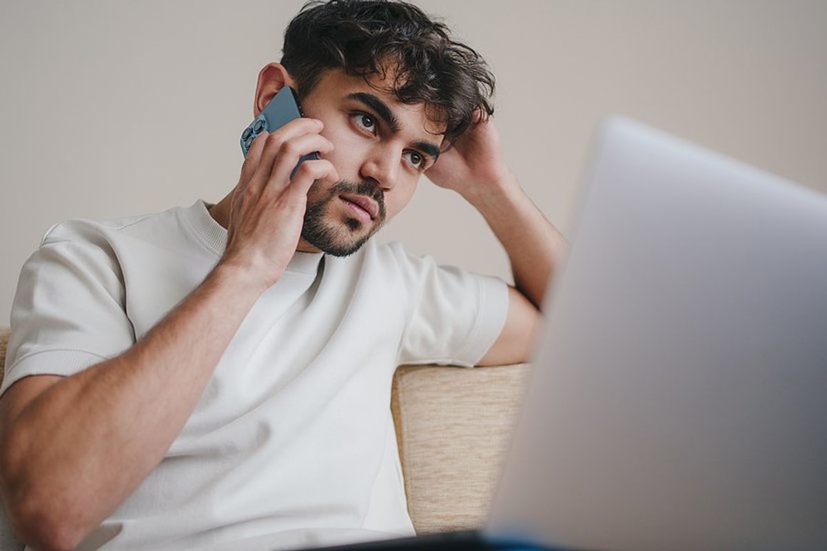 Unemployed white-collar worker on laptop and phone tries to find a job