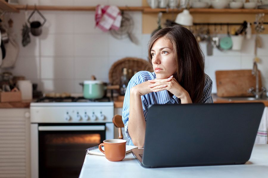 Unemployed woman stares out the window as she looks for a job
