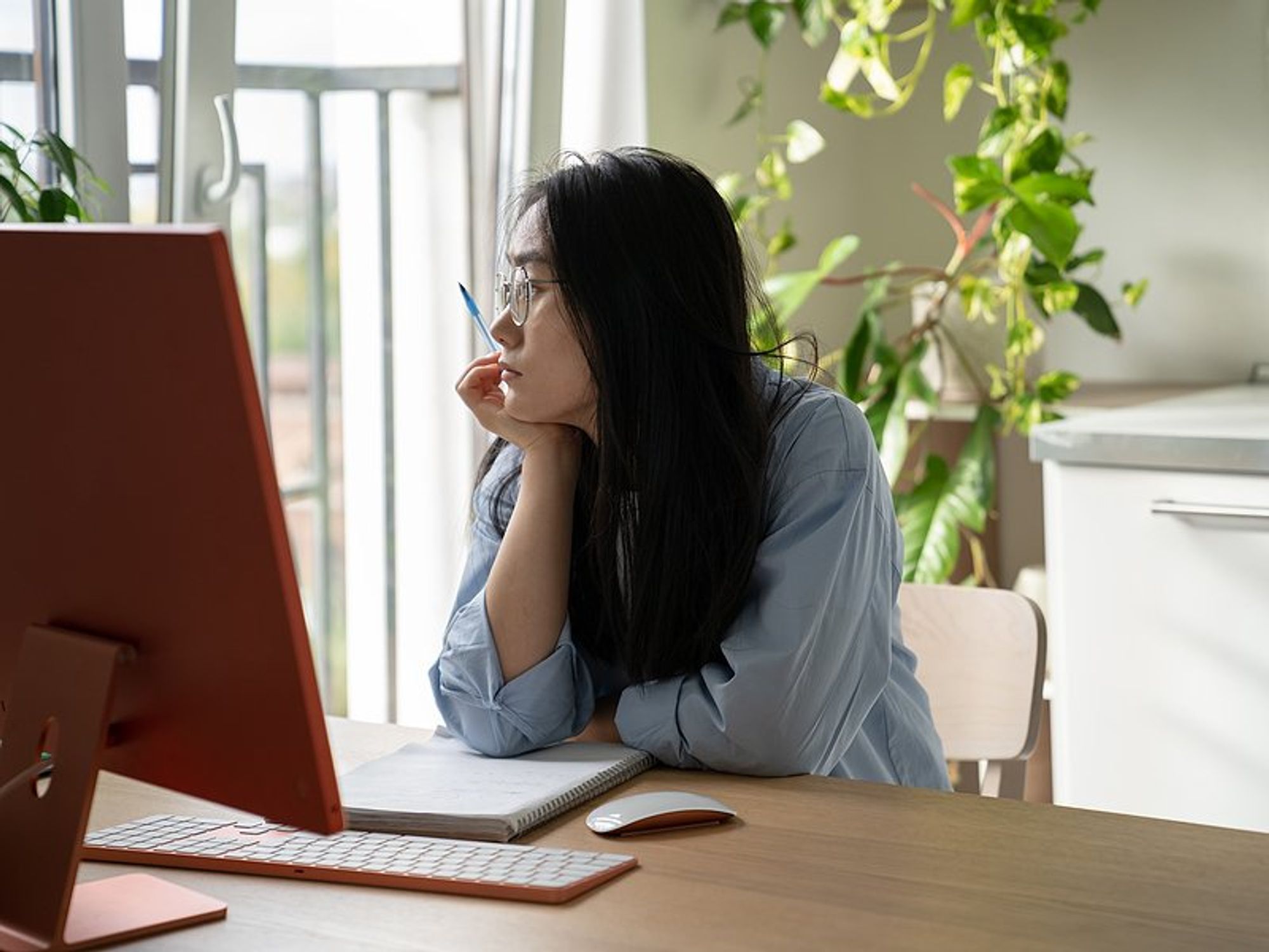Unmotivated young professional at work looks out the window