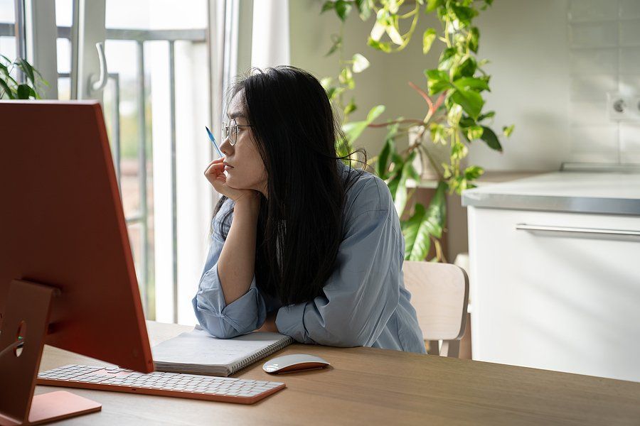 Unmotivated young professional at work looks out the window