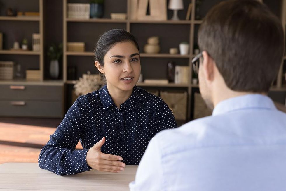 Une femme répond à une question lors d'un entretien d'embauche
