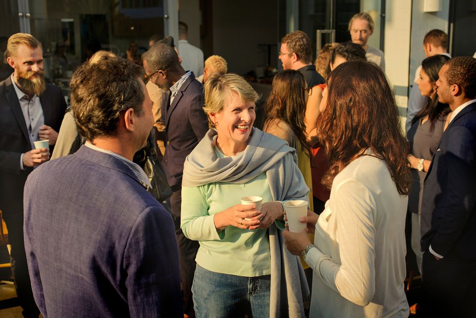 Mujer en un evento de networking hablando con colegas que podrían ayudarla con su cambio de carrera