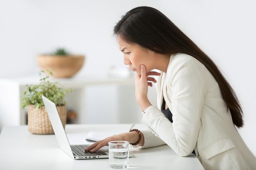 Woman confused as she edits her resume on her laptop