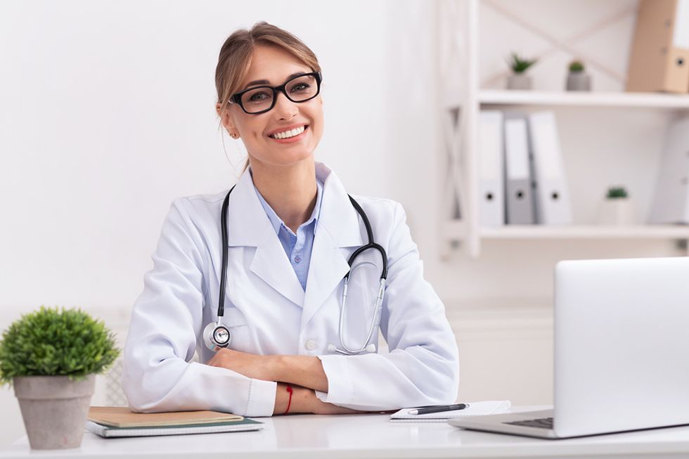 Woman doctor smiles at her desk