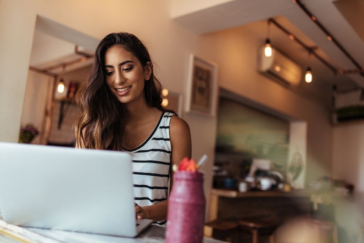 Woman drinks a smoothie while working